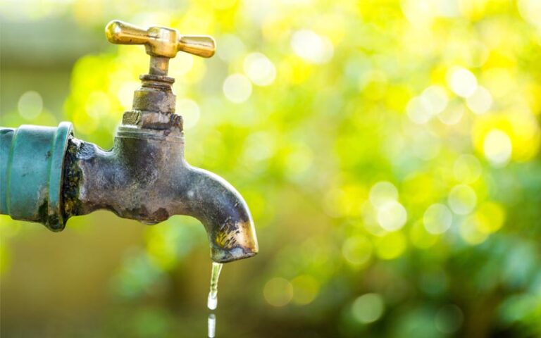 Acqua in giardino: foto di un rubinetto che perde